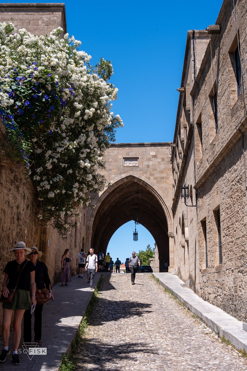 Pointed stone arch opening onto a bright street