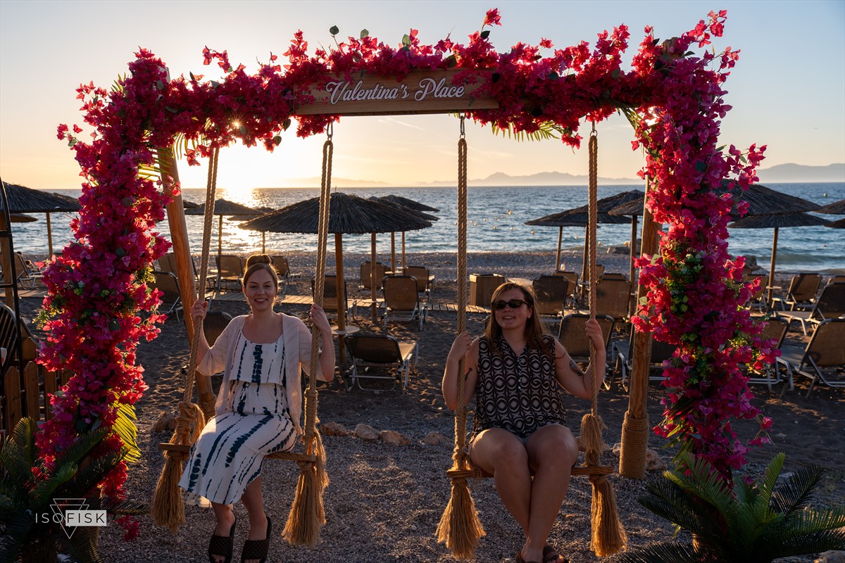 Flower-covered swing frame overlooking the sea at sunset