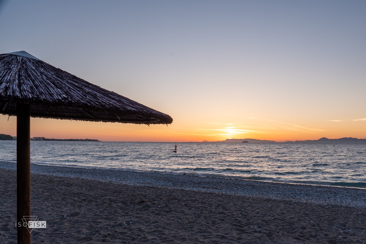 Beach parasol beside the sea at sunset