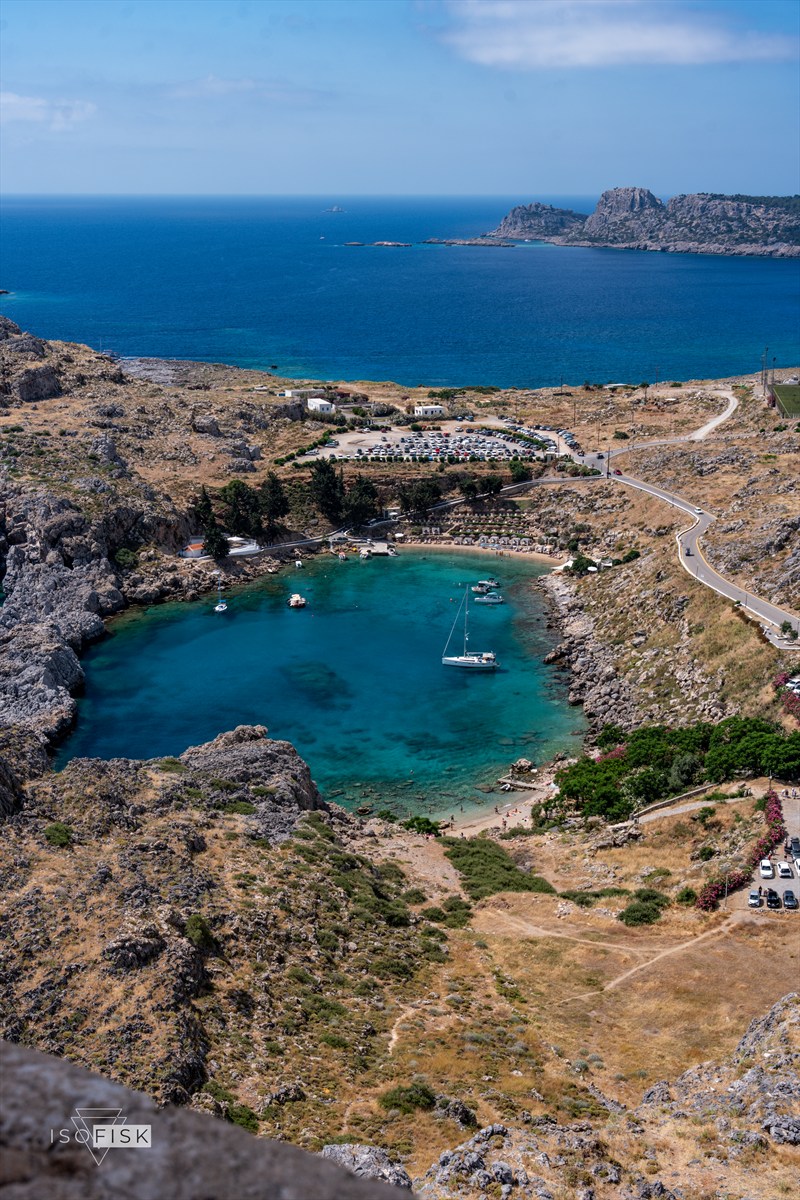 Turquoise bay with sailing boats surrounded by rocky hills