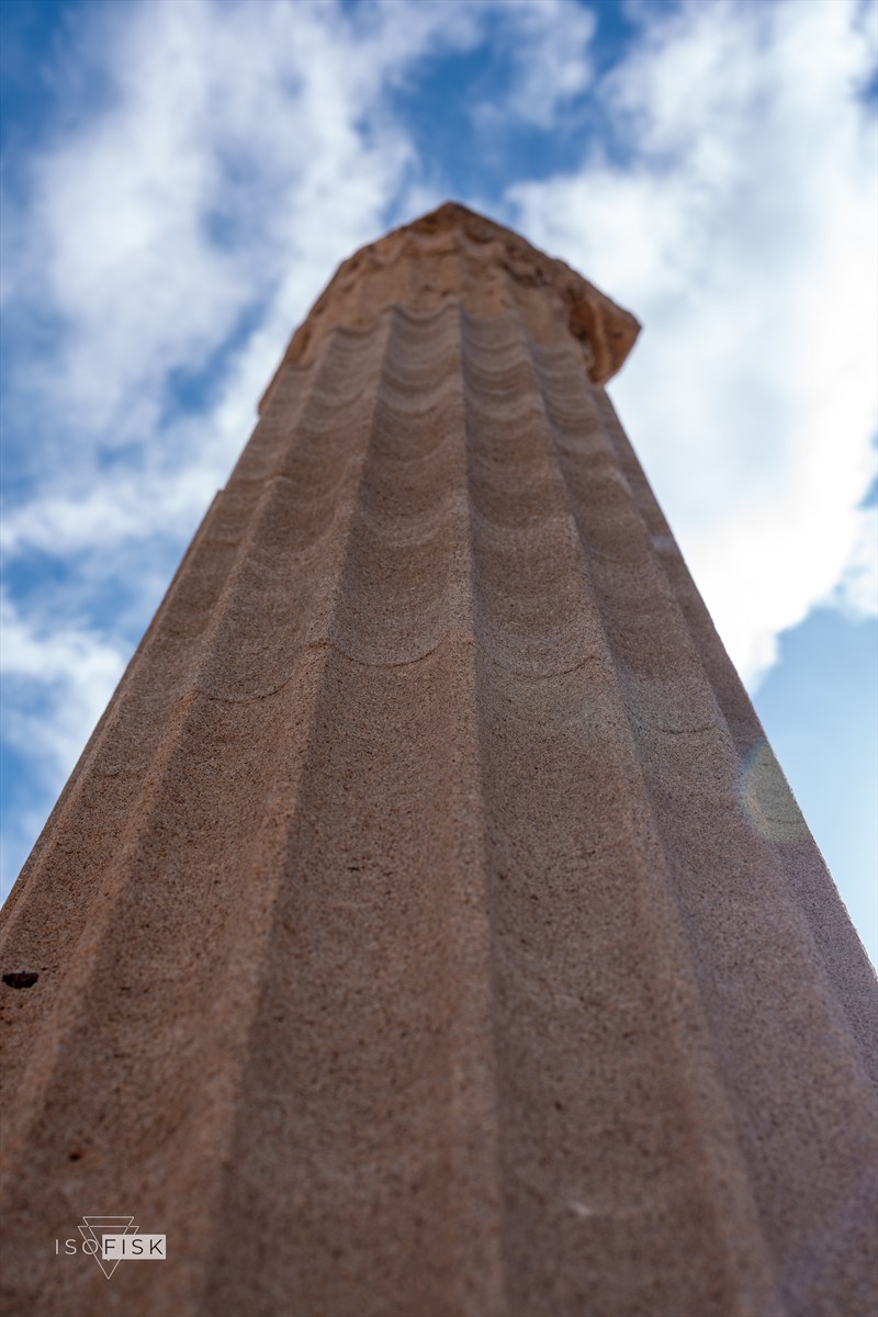 Low angle view of an ancient stone column against clouds
