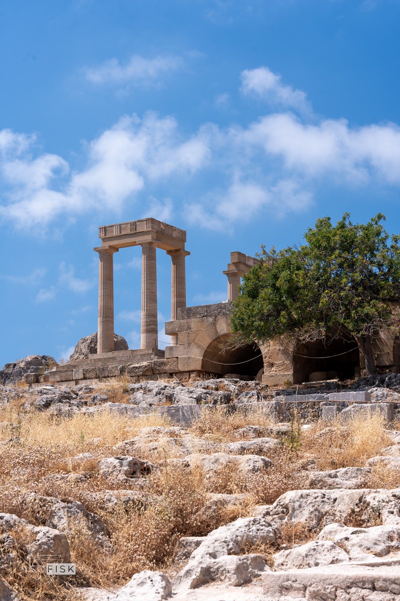 Stone columns and ancient ruins beneath a blue sky