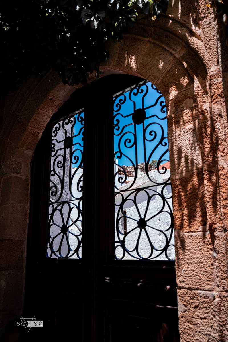 Decorative iron gate within a stone archway