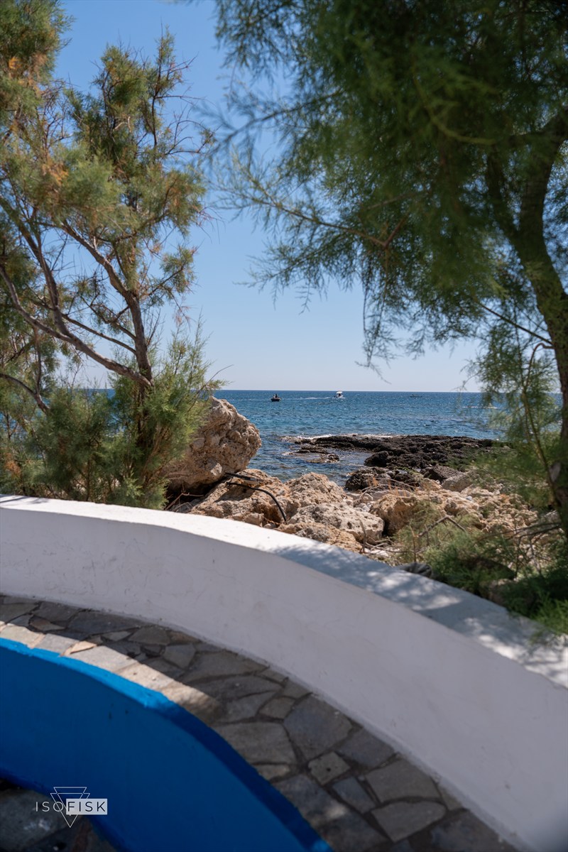 Blue and white wall looking towards a rocky coastline