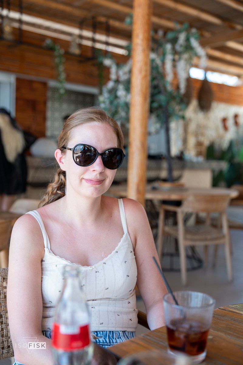 Person smiling at an outdoor beachside table