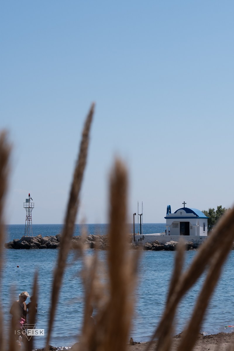 Blue-domed chapel and lighthouse beside the sea