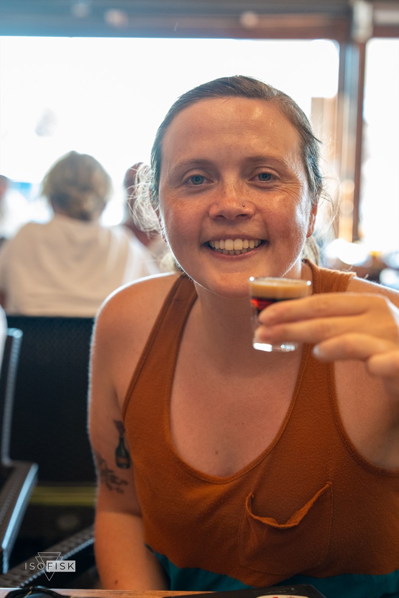 Person holding a small drink and smiling
