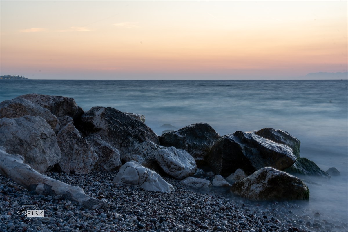 Smooth water moving around rocks at blue hour